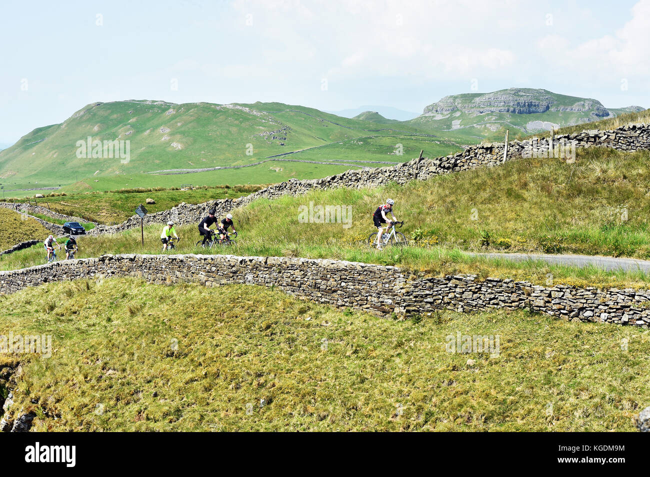 Cyclists cycling in the Yorkshire Dales UK travelling through beautiful scenery near Settle Stock Photo
