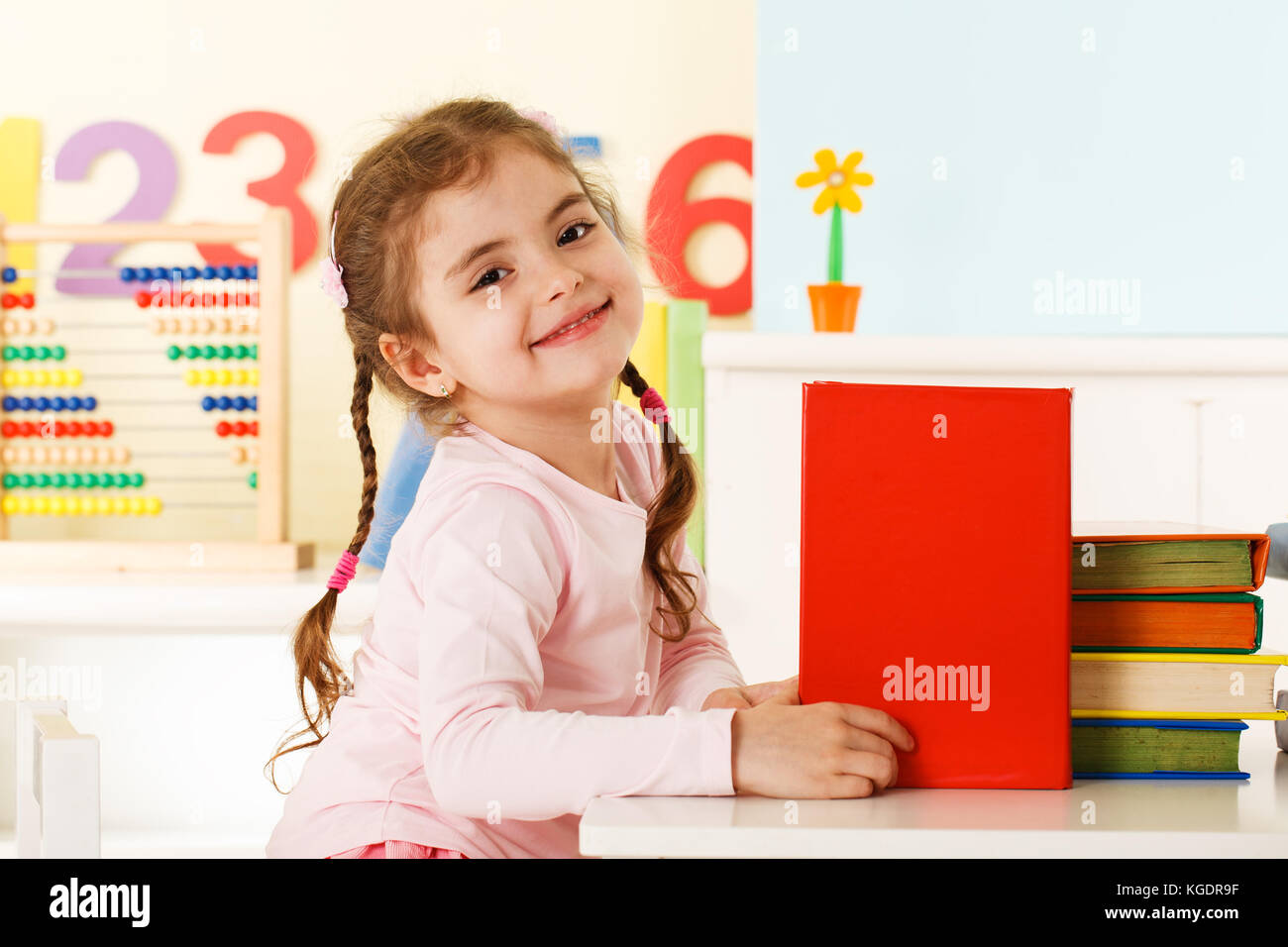 Preschool girl with a books Stock Photo - Alamy