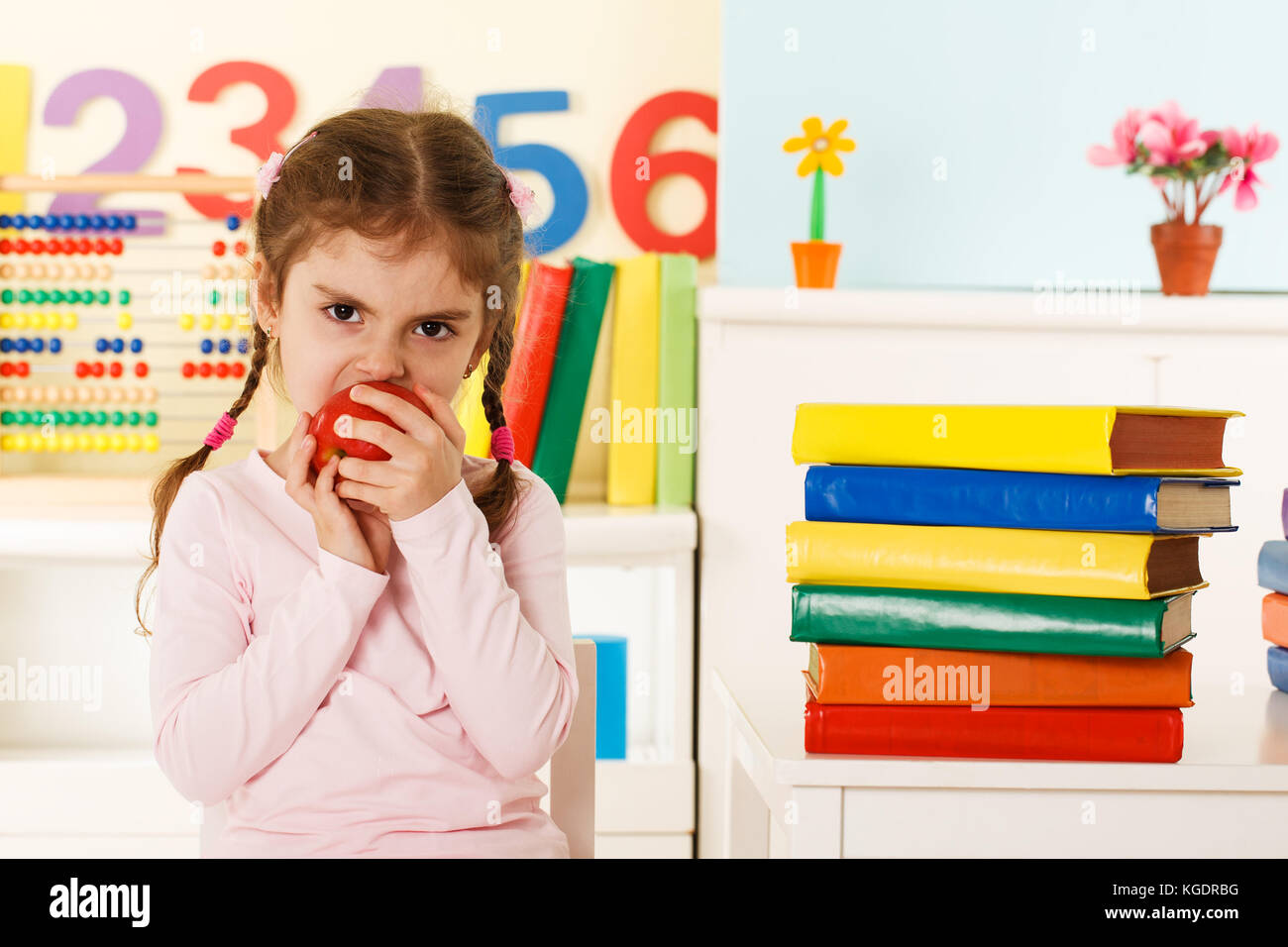 Preschool girl eating red apple Stock Photo