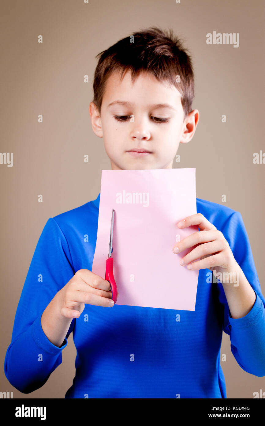 Boy cutting colored paper with scissors Stock Photo Alamy