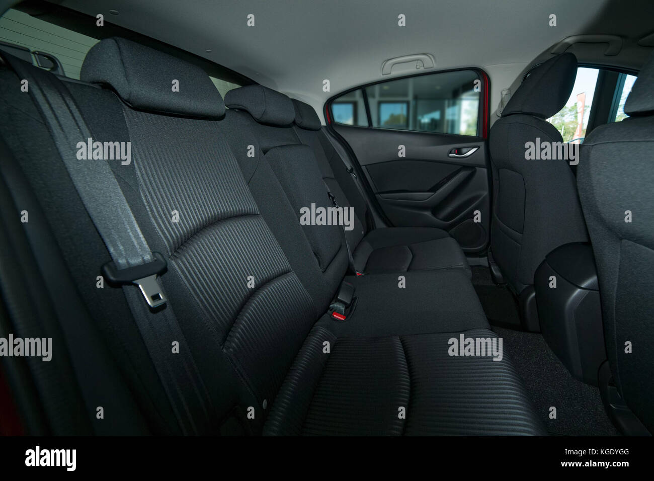 Modern car interior with back seat with seat belts, front seats and roof with a grab handle Stock Photo