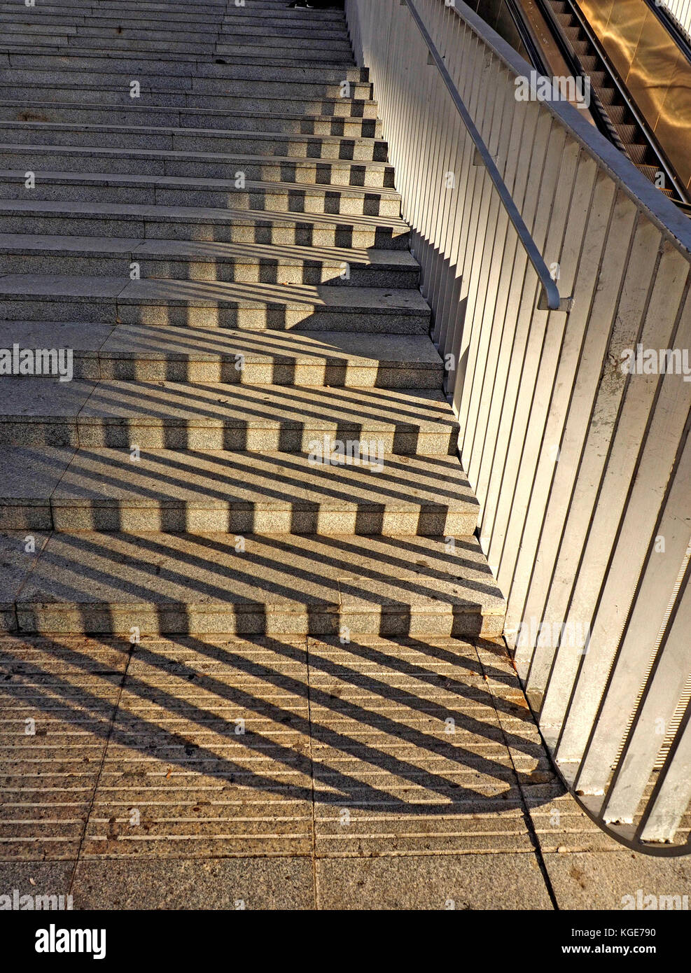 zigzag patterns formed by shadows of railings onto steps leading up to