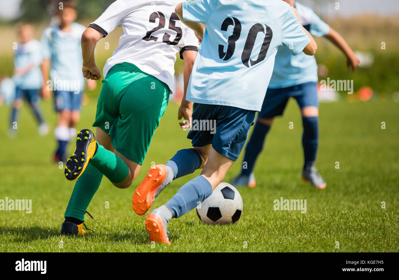 Boys Kicking Soccer Match on Grass. Youth Football Game. Children Sport Competition. Kids Playing Outdoor Stock Photo