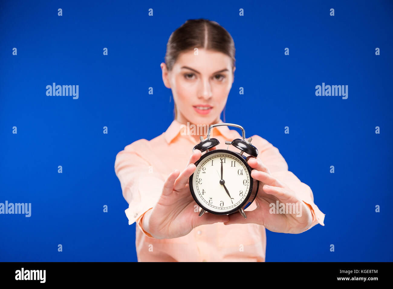 young girl with an alarm clock in focus Stock Photo Alamy