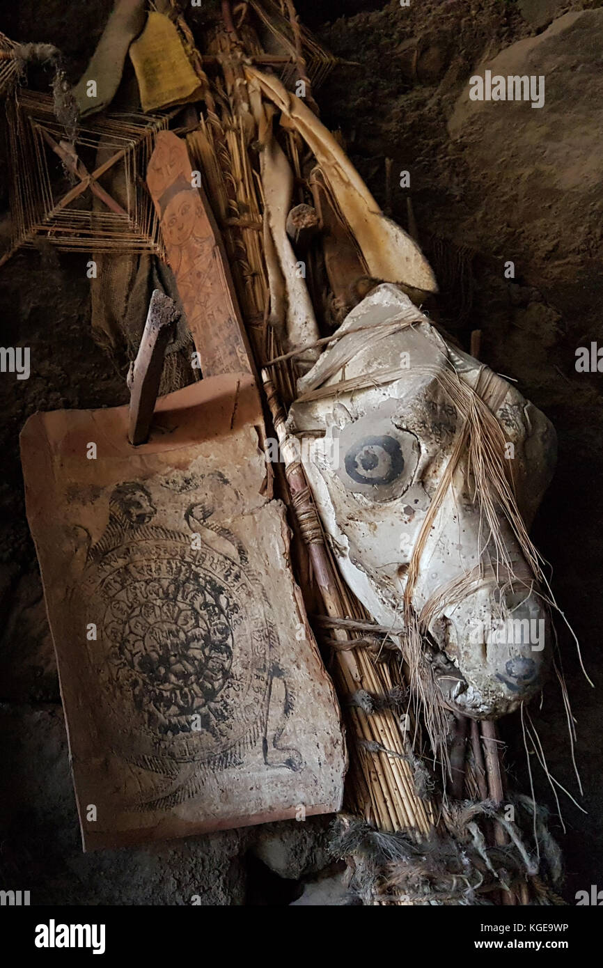 An ancient Tibetan mascot, an amulet, a guard of a Buddhist house: a skull of a dog with painted eyes among wooden slats, on the left is an old Buddhist calendar, Ladakh. Stock Photo