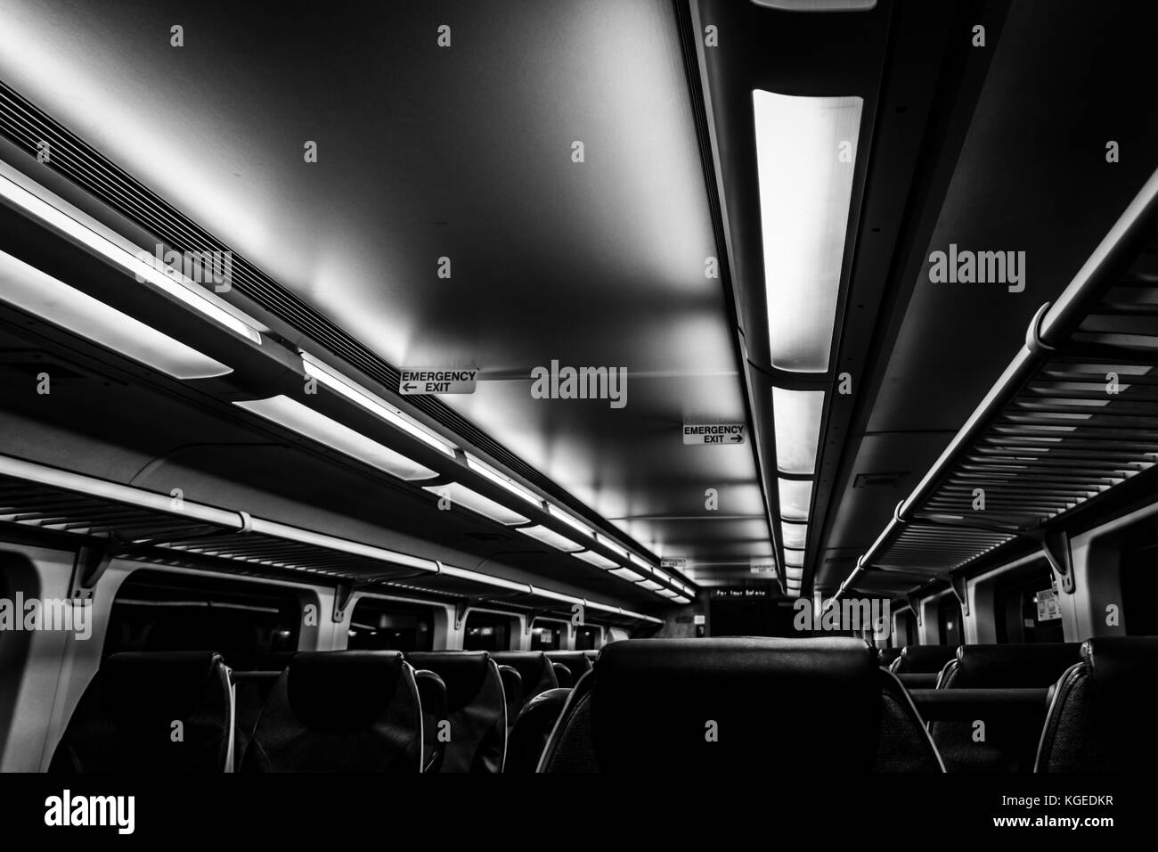 Dover, NJ USA - November 1, 2017:  New double-decker NJ Transit train at night with empty seats, black and white Stock Photo