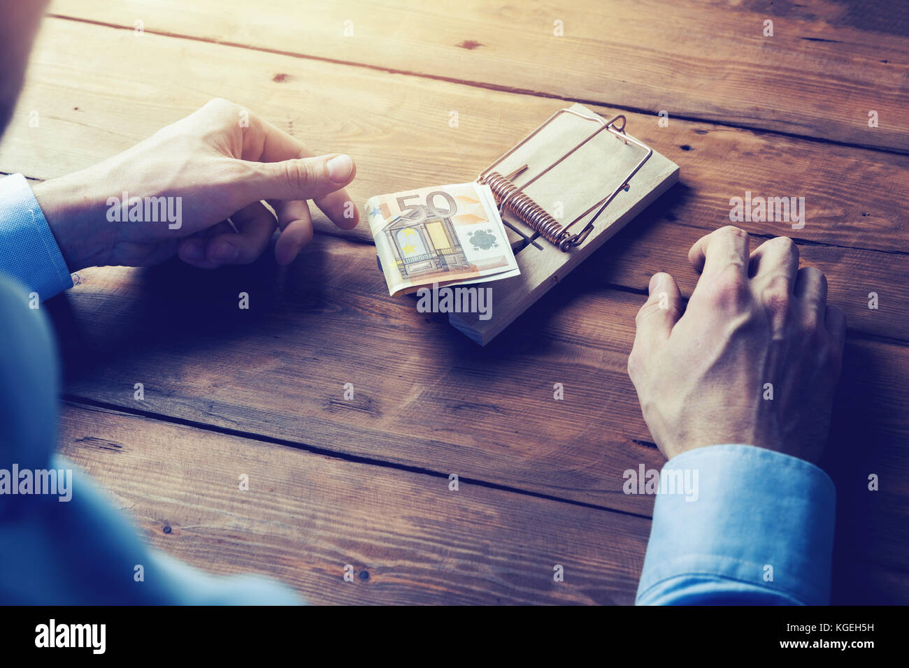 temptation concept - businessman ready to risk and take money from mouse trap Stock Photo