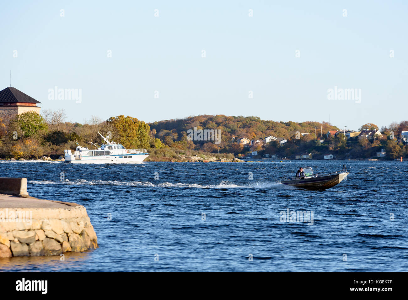 Karlskrona, Sweden - October 30, 2017: Documentary of everyday life and environment. Fisherman in motorboat with fall coastal landscape in background. Stock Photo