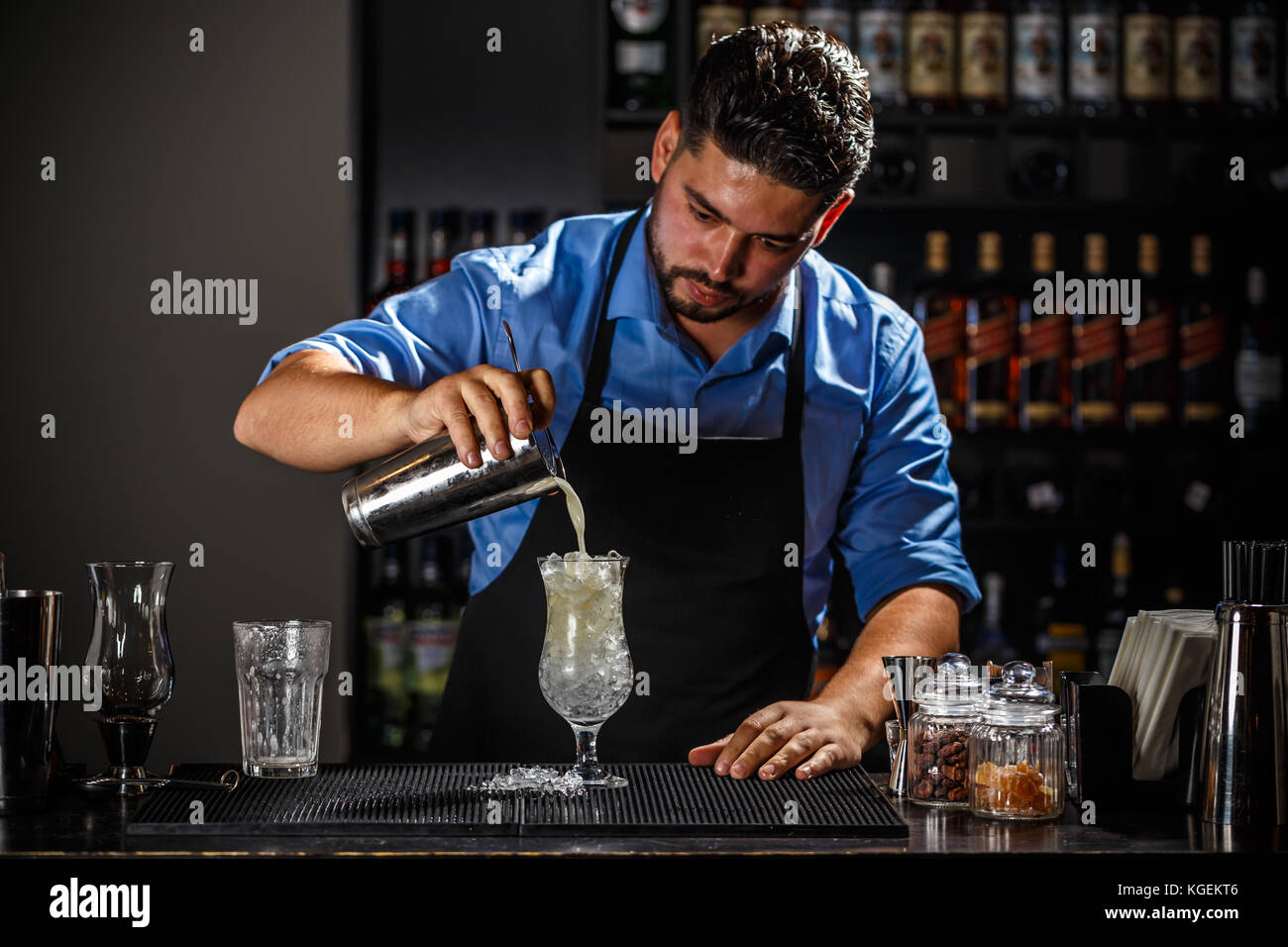 Barman with shaker preparing pina colada cocktail at bar Stock Photo