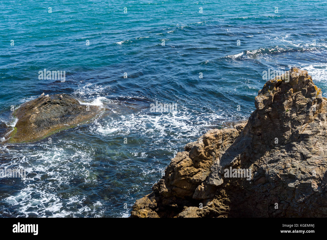 Blue sea, waves and rocky shore Stock Photo - Alamy