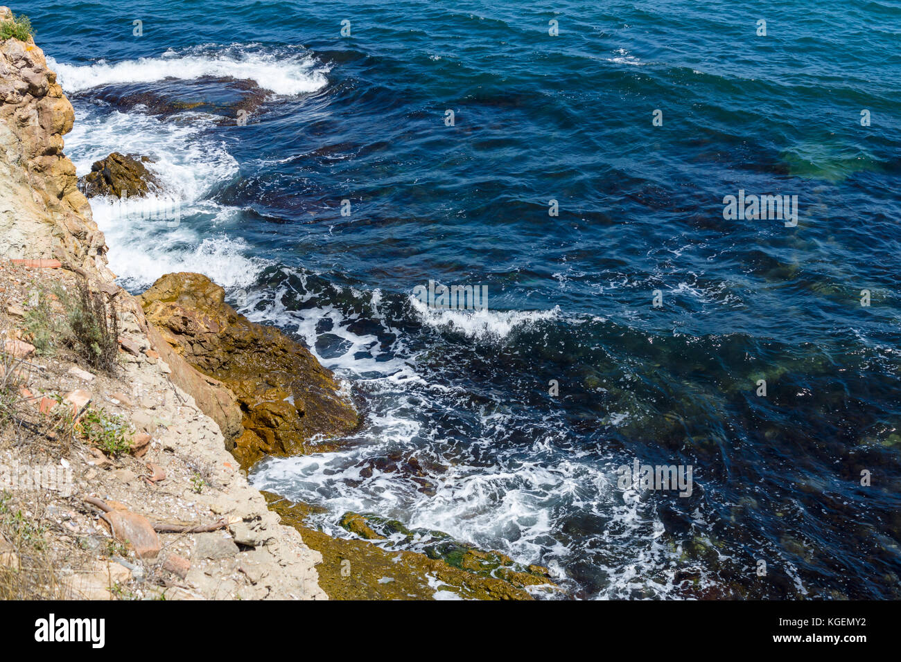 Blue sea, waves and rocky shore Stock Photo - Alamy