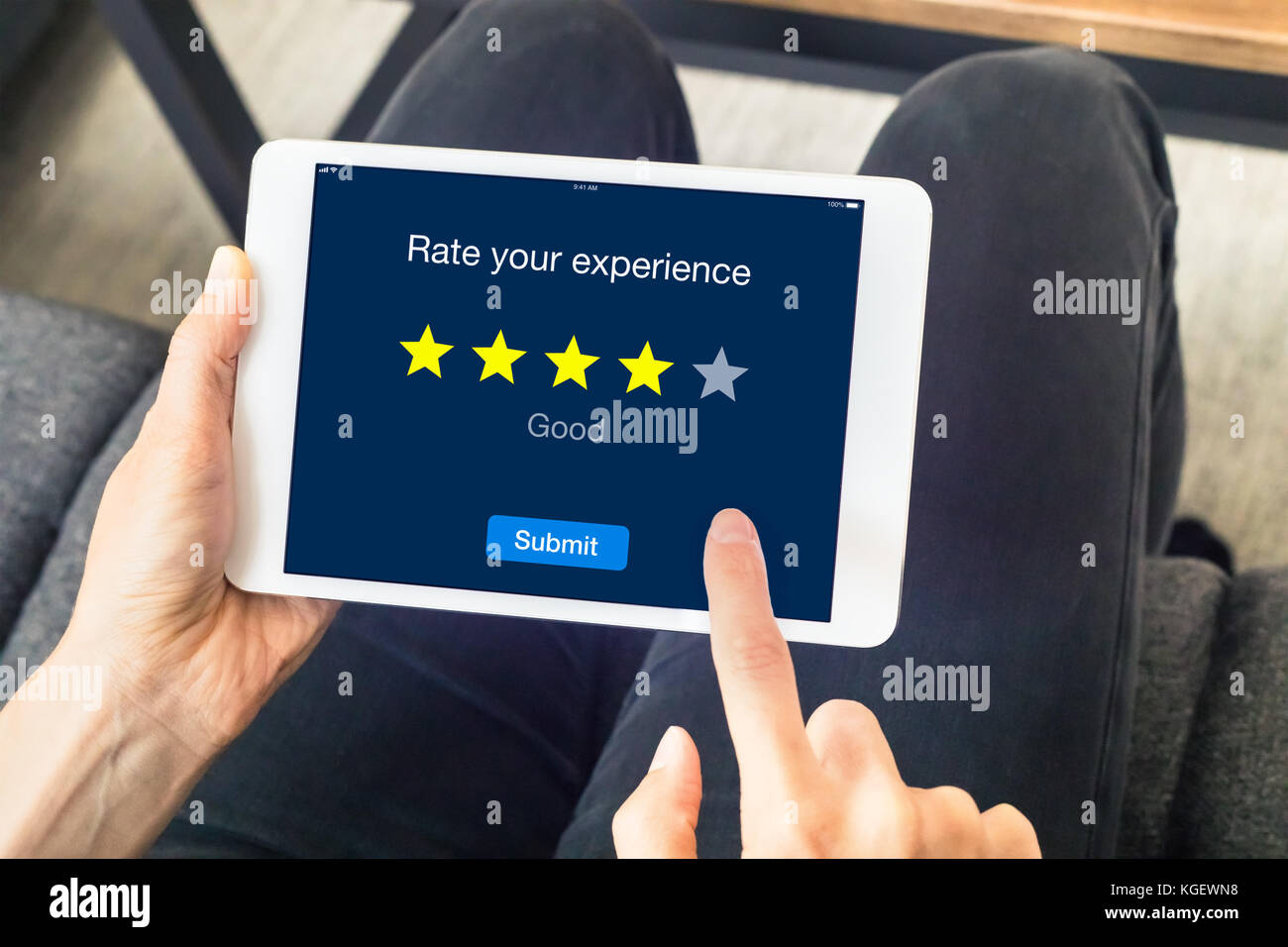 Person using digital tablet computer at home to send customer rating with online website, satisfaction review based on star icons, concept about quali Stock Photo
