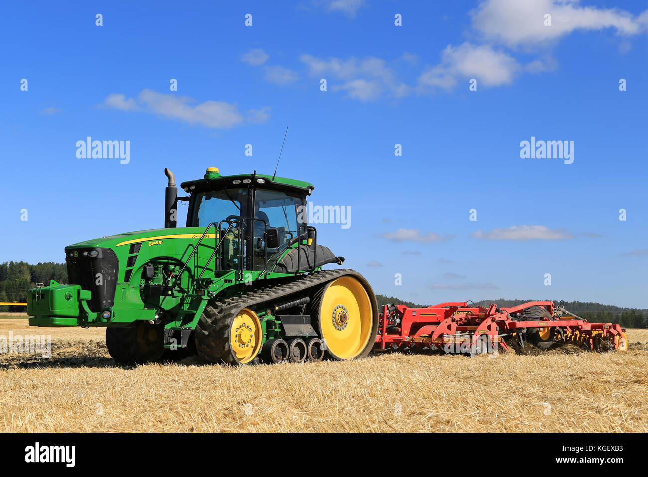 SALO, FINLAND - AUGUST 22, 2015: Unnamed farmer cultivates the field with John Deere 8345RT tracked tractor and Vaderstad cultivator at Puontin Peltop Stock Photo