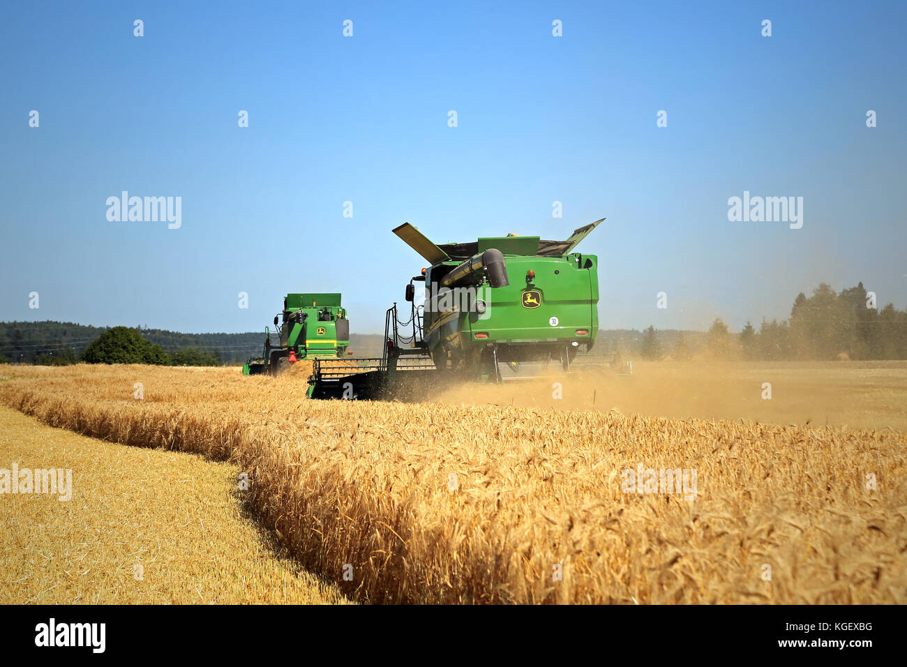 SALO, FINLAND - AUGUST 22, 2015: Two John Deere modern Combines harvest barley at Puontin Peltopaivat Agricultural Harvesting and Cultivating Show. Stock Photo