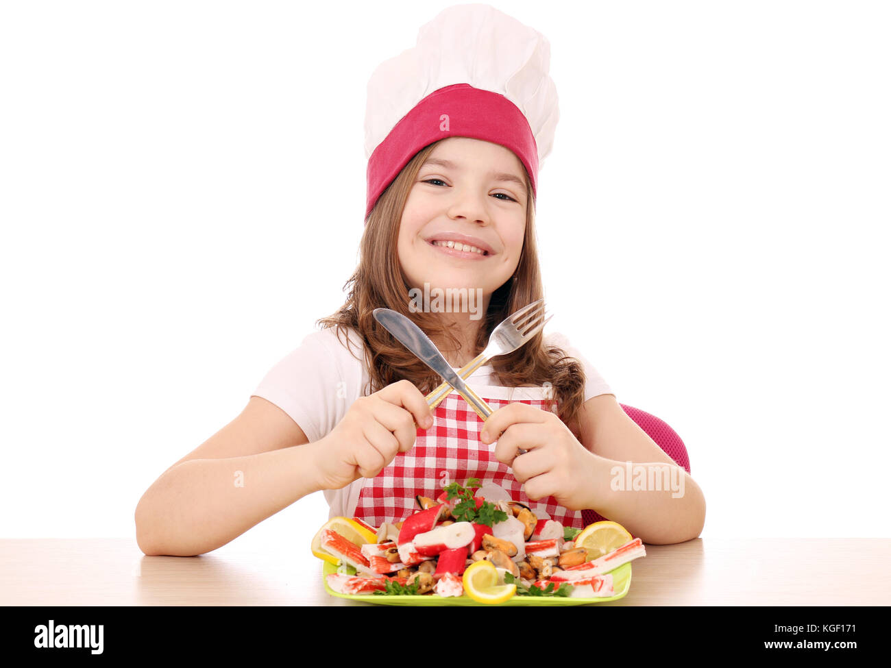 happy little girl cook with seafood on table Stock Photo