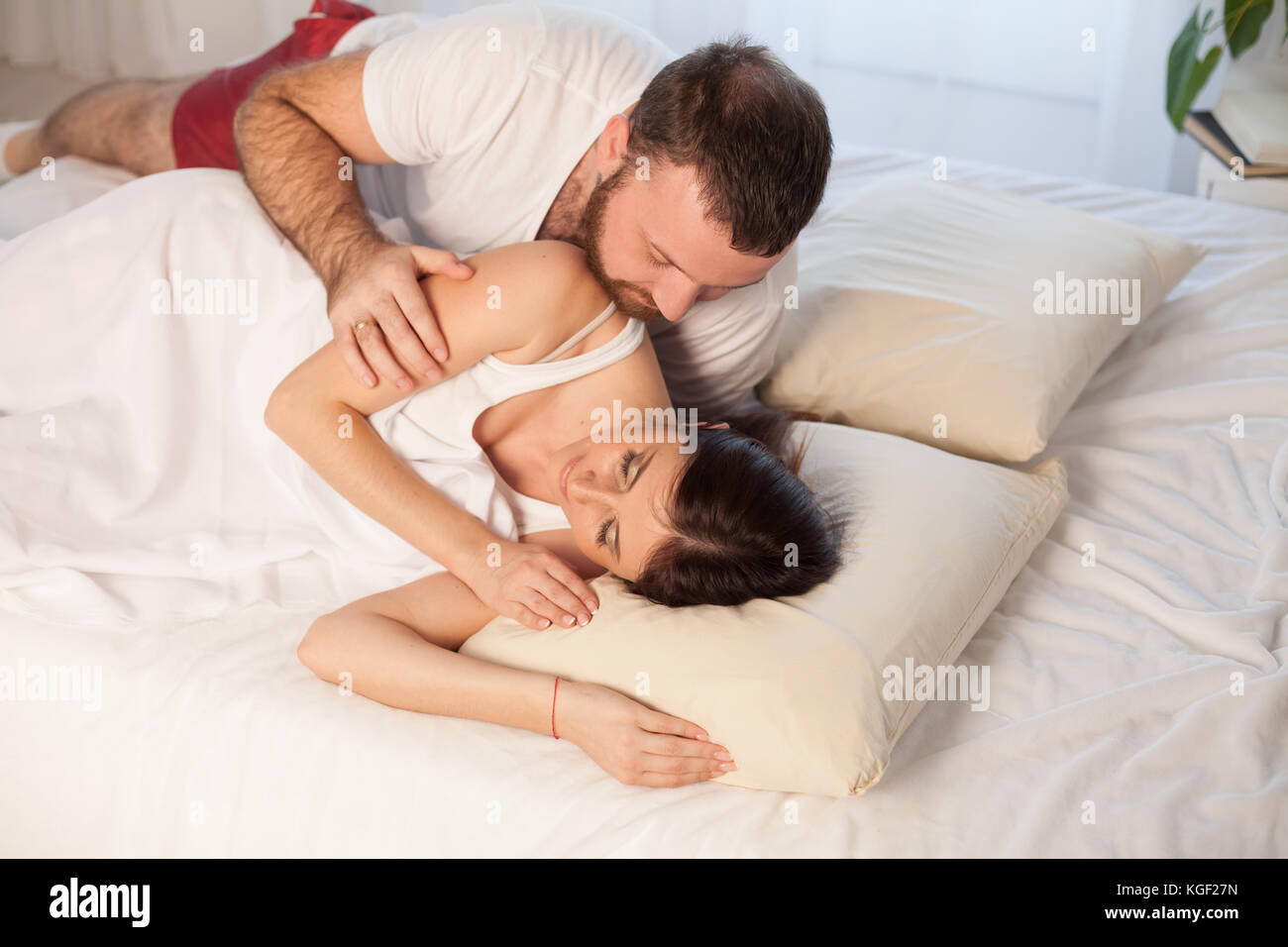 man wakes a woman in the bedroom in the morning weekend Stock Photo