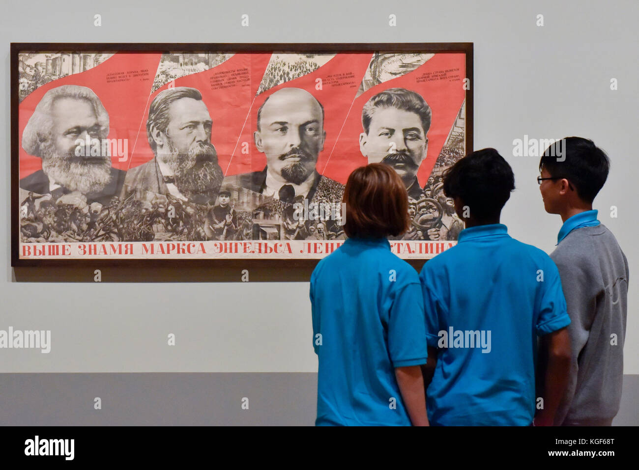 London, UK. 7th Nov, 2017. Students from Thomas Tallis School, Kidbrooke, south London, look at 'Under the Banner of Marx, Engels, Lenin and Stalin!', 1933, by Gustav Klutsis, at a preview of 'Red Star Over Russia: A Revolution in Visual Culture 1905-55' at Tate Modern. The exhibition marks the centenary of the October Revolution and presents the visual history of Russia and the Soviet Union with works drawn primarily from the collection of the late graphic designer David King. Credit: Stephen Chung/Alamy Live News Stock Photo