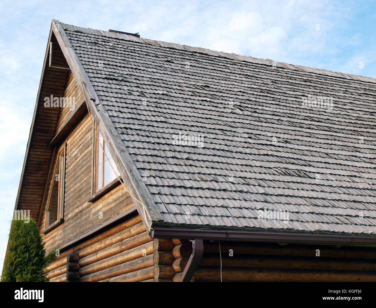 Part of house with weathered wood shingle roof Stock Photo