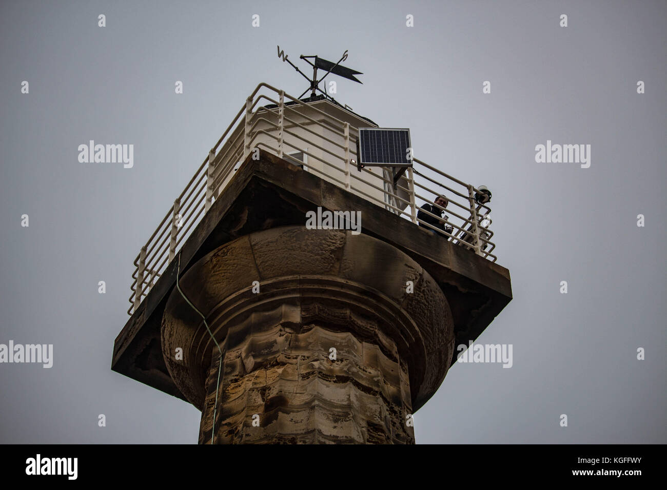 Whitby lighthouse, looking up at a lone man looking out to see on a cold autumn day. I love the the detail that you can see in the brickwork.Cold Stock Photo
