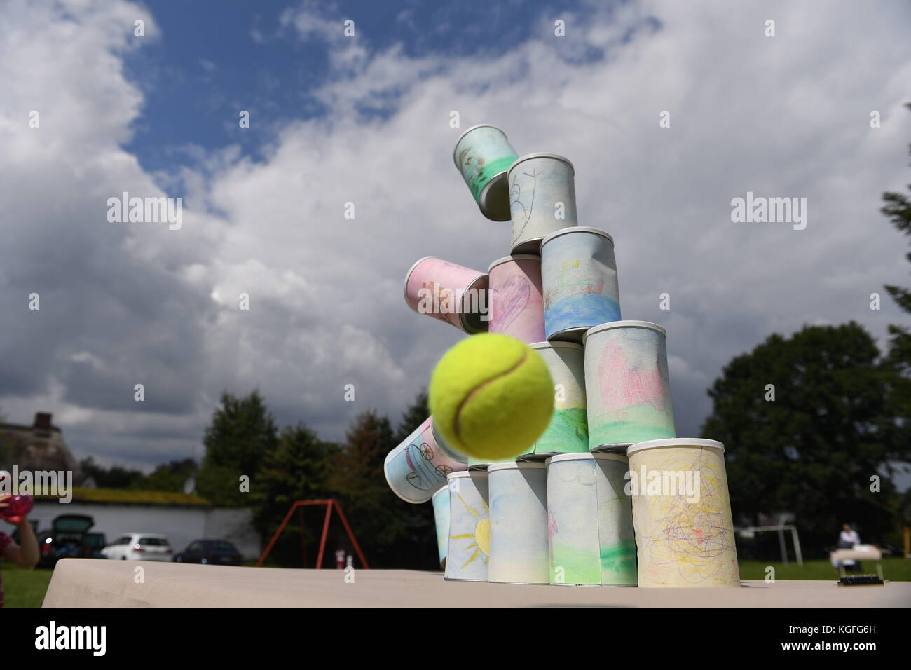kids throwing a ball at cans Stock Photo