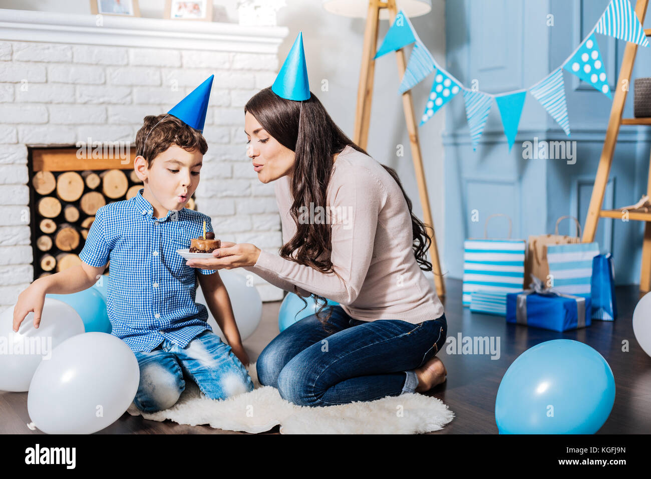 Pleasant mother blowing out candles with her son Stock Photo Alamy