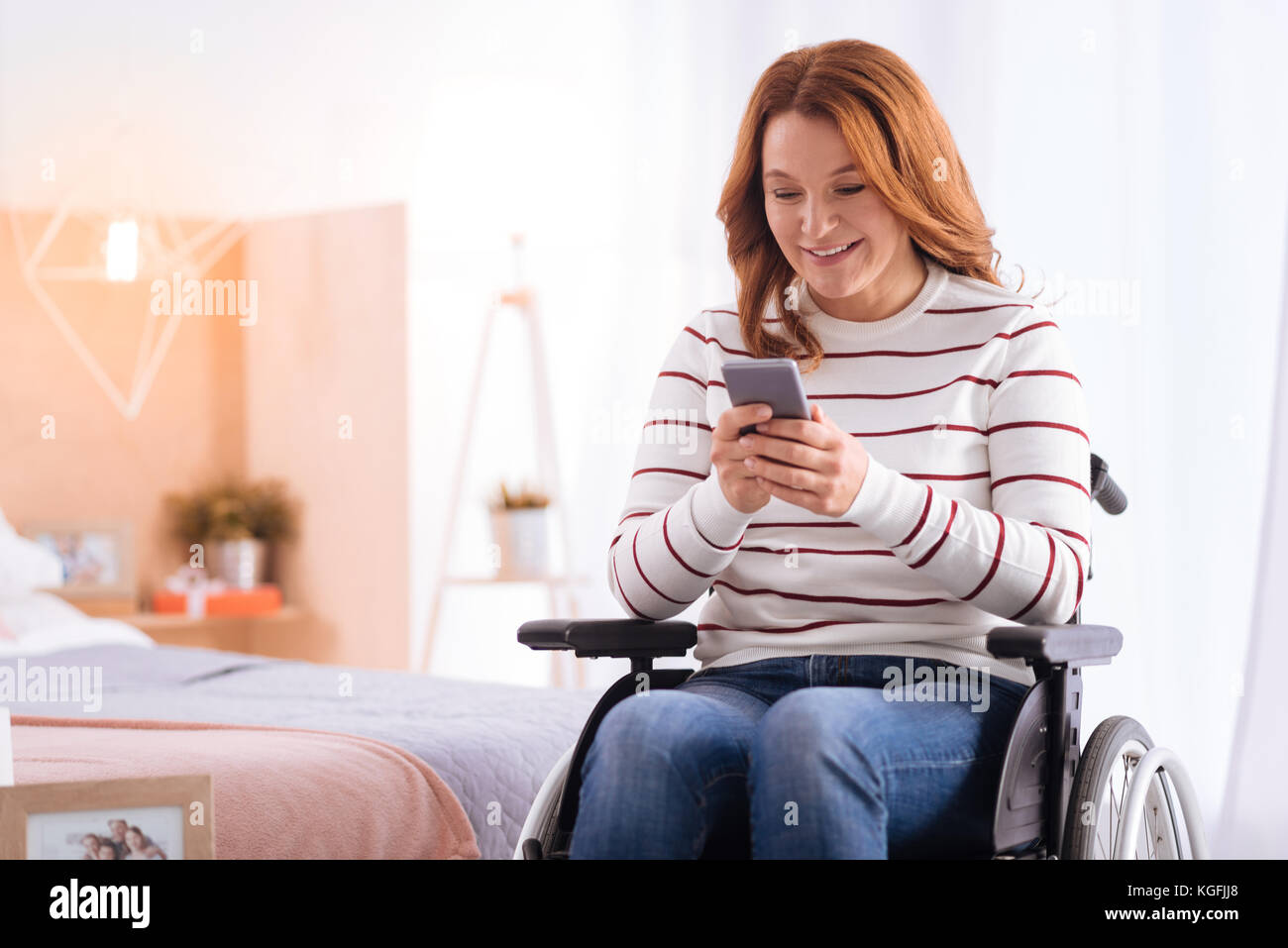 Alert woman sitting in a wheelchair with her phone Stock Photo - Alamy