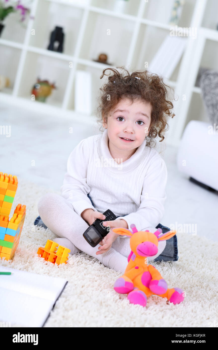 Portrait of a little girl playing with colorful cubes toys at home ...