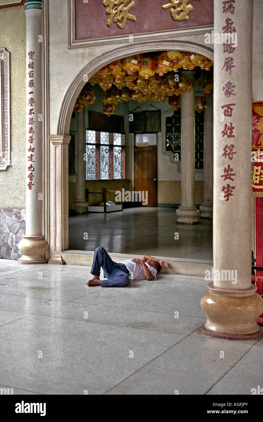 Drunken man asleep at a Chinese temple. Thailand people. Stock Photo