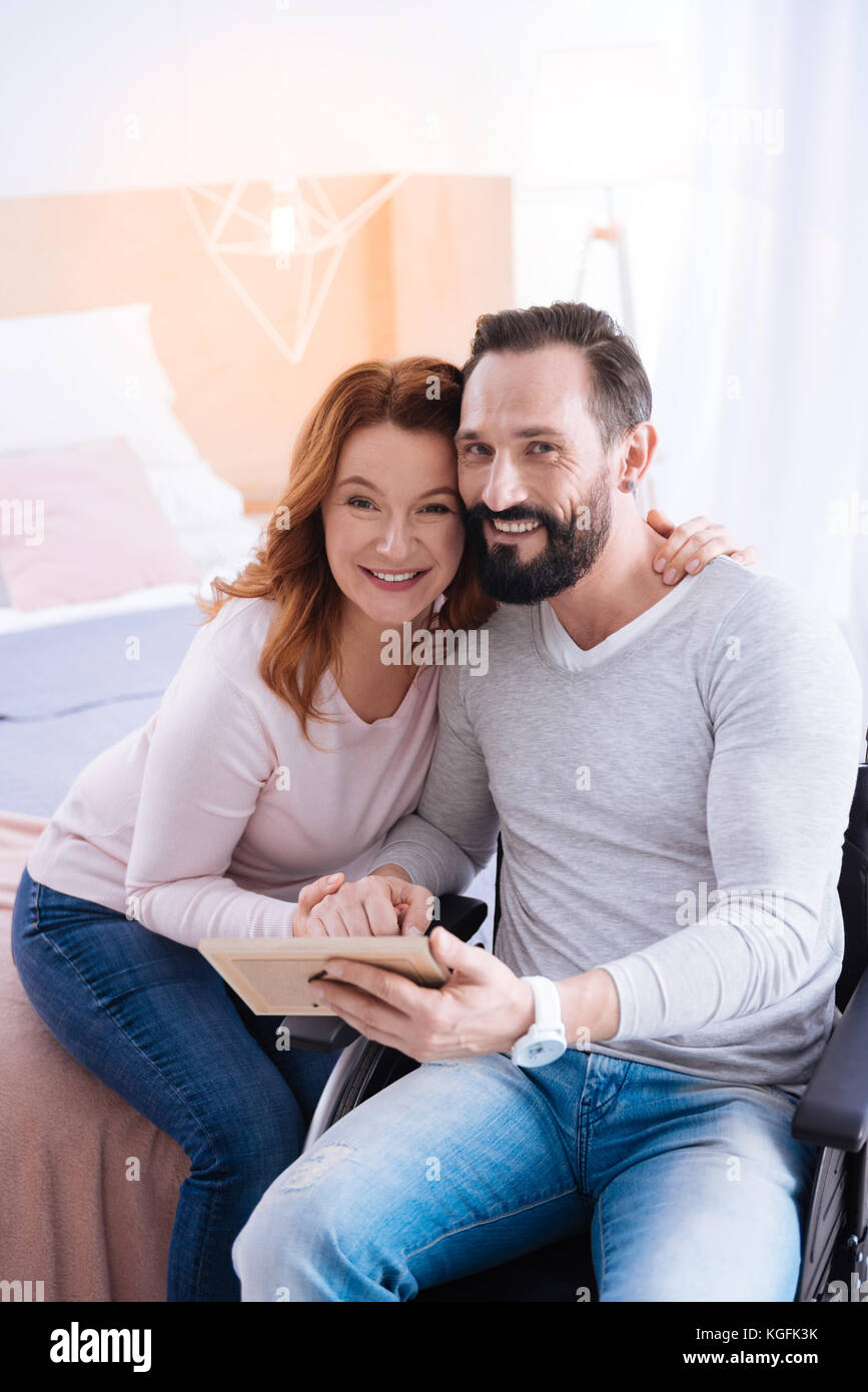 Glad woman and paralyzed man hugging Stock Photo