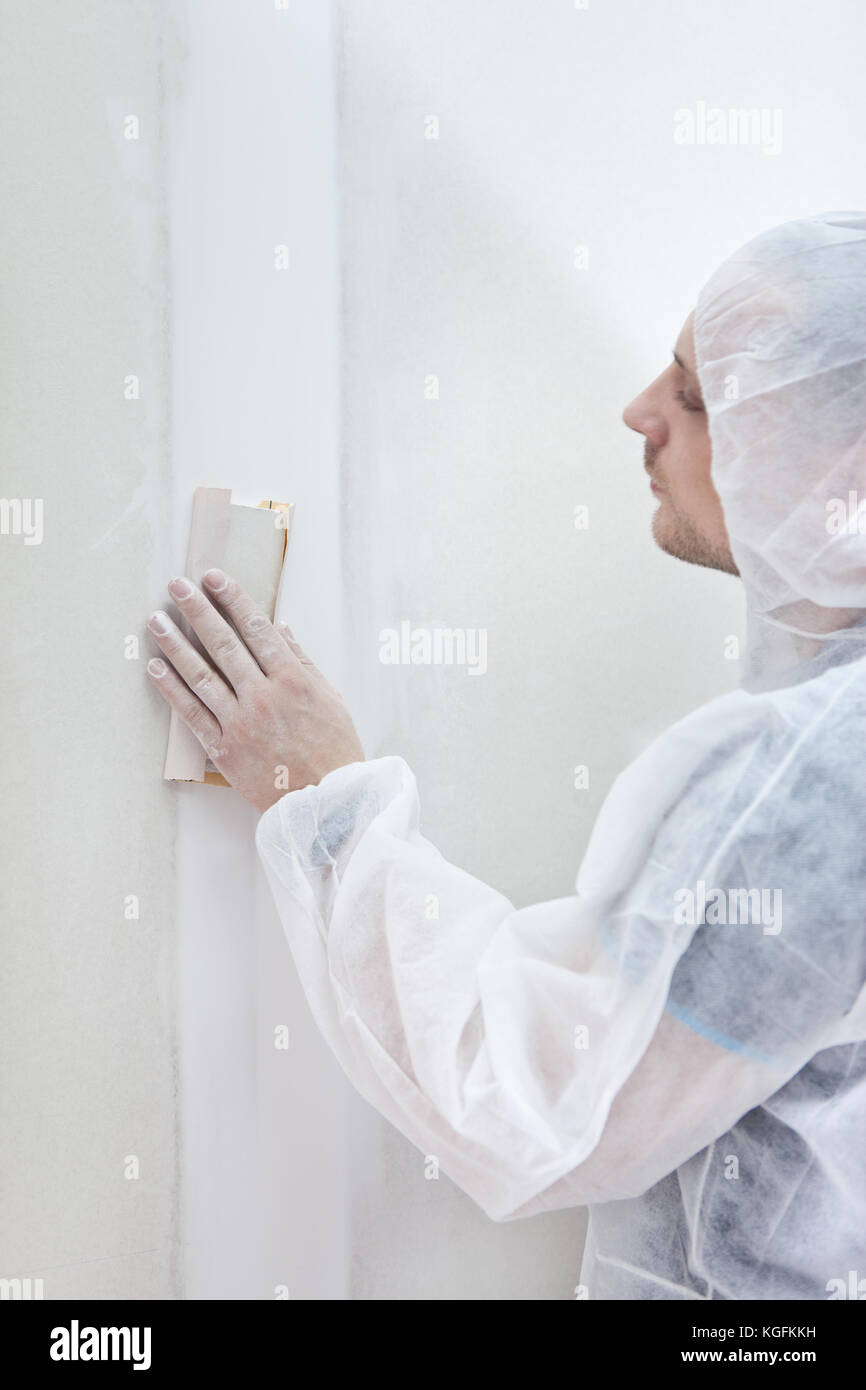 Apartment repair, processing of a wall by an sandpaper Stock Photo Alamy