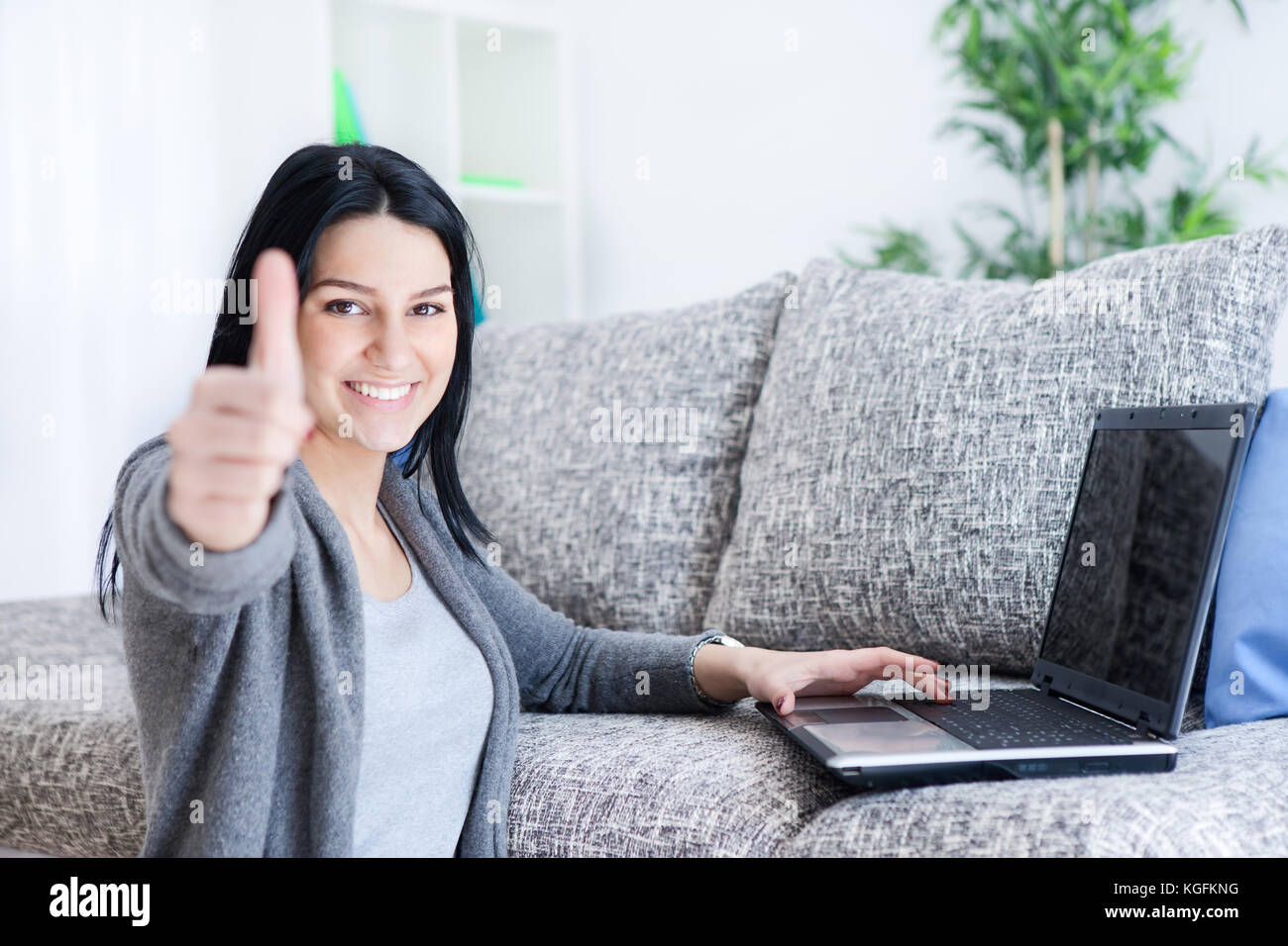 smiling young girl with thumb up , working on laptop Stock Photo - Alamy