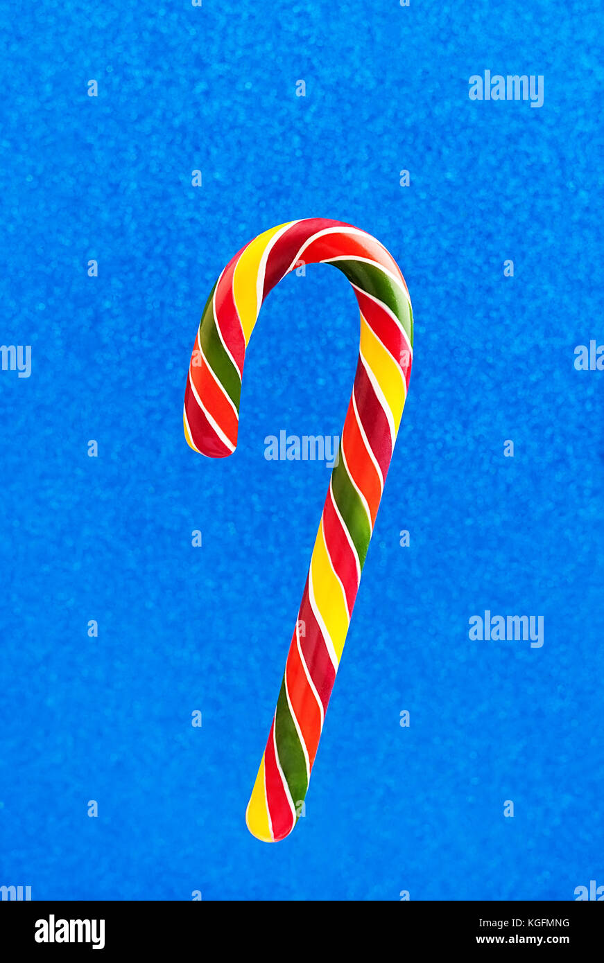 Christmas colored lollipop candy cane on blue glitter glossy background Stock Photo