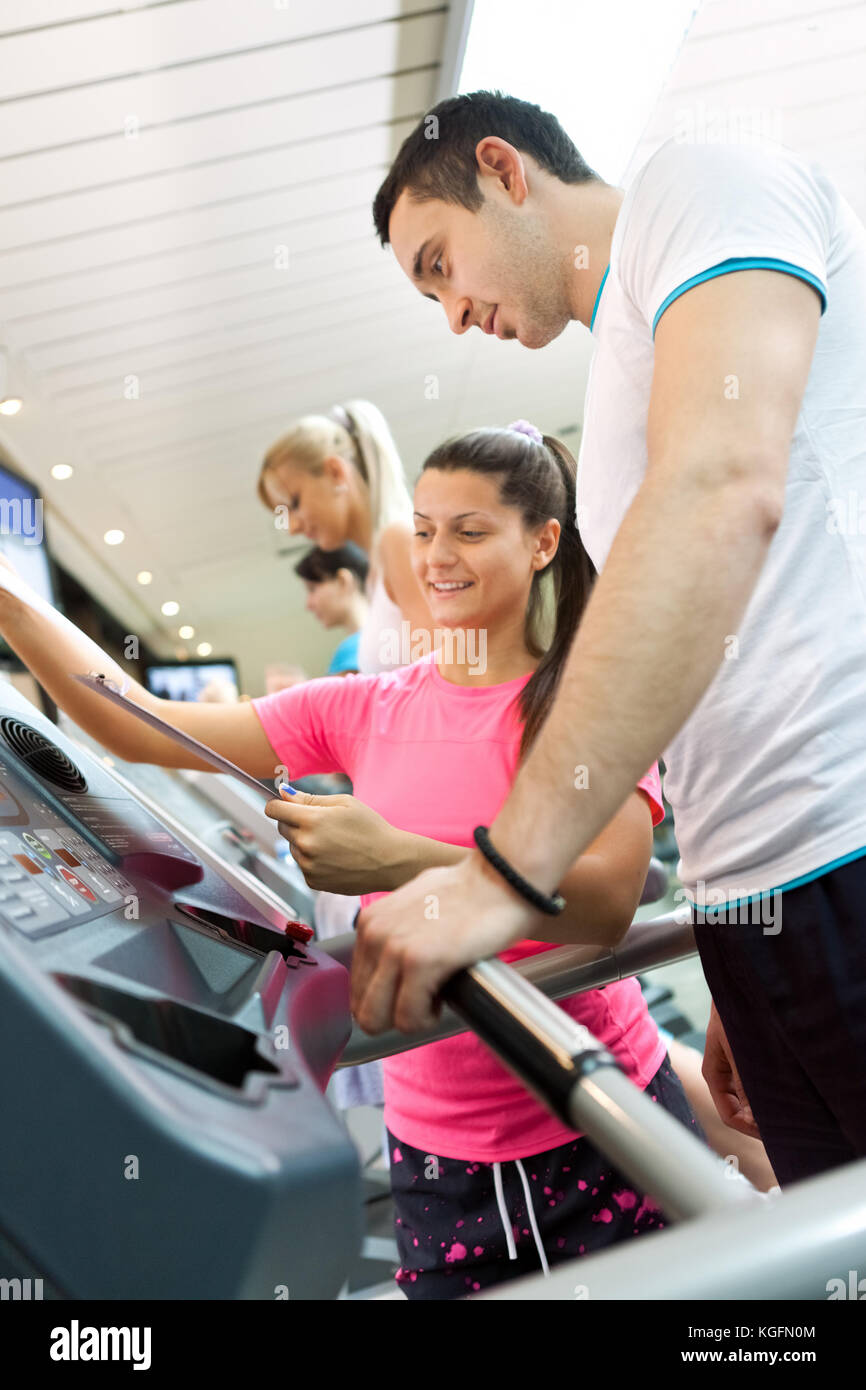young man walking on a treadmill with his personal trainer Stock Photo