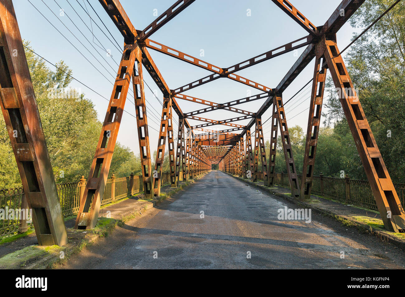 Old rusty empty bridge over Tisa river in Vylok, close to border with Hungary. It is a village in western Ukraine, Zakarpattia region. Stock Photo