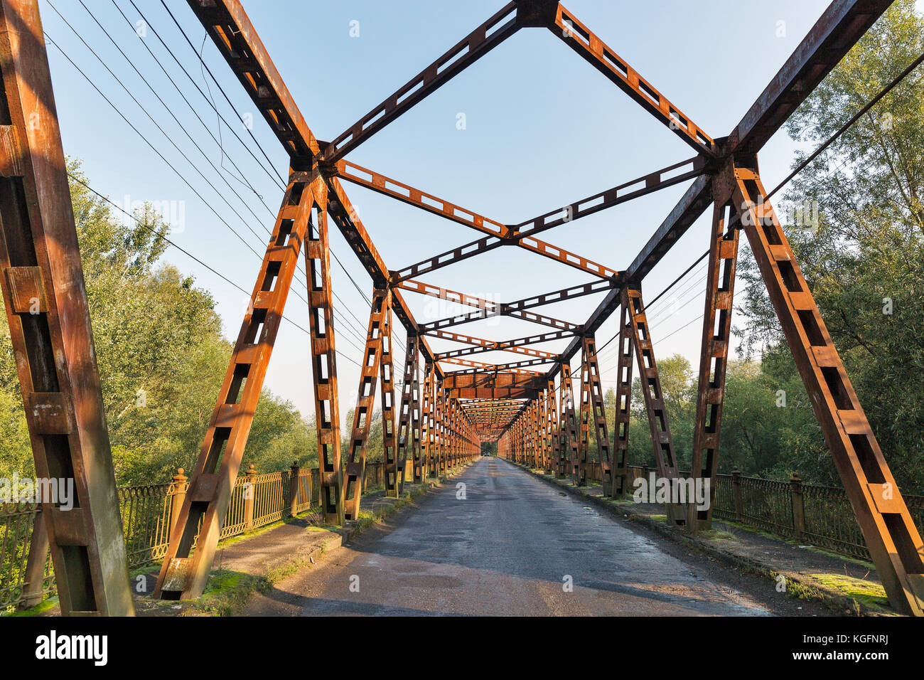 Old rusty empty bridge over Tisa river in Vylok, close to border with Hungary. It is a village in western Ukraine, Zakarpattia region. Stock Photo