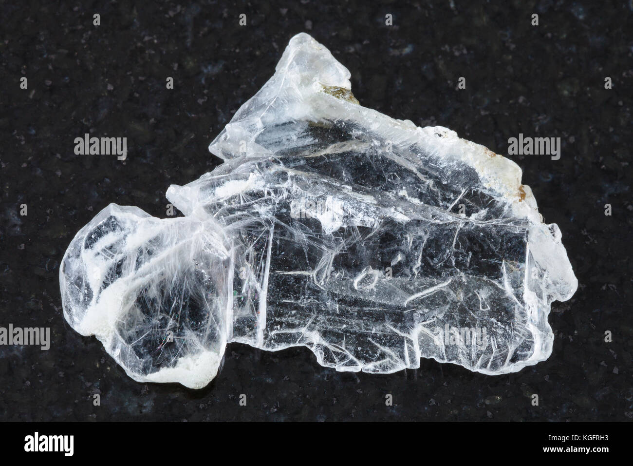 macro shooting of natural mineral rock specimen - raw layer of Brucite stone (Magnesium oxide ore) on dark granite background from Sverdlovsk Region,  Stock Photo