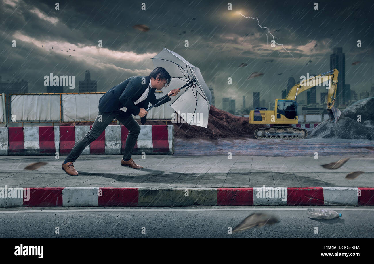 Businessman with White umbrella protecting himself from the storm ...