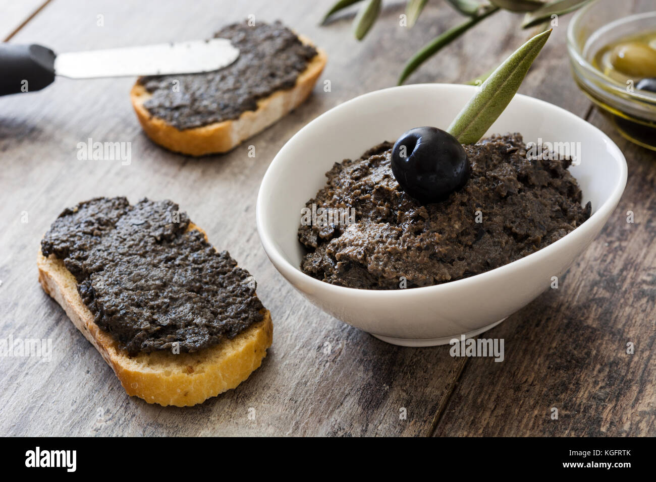Black olive tapenade with anchovies, garlic and olive oil on wooden ...