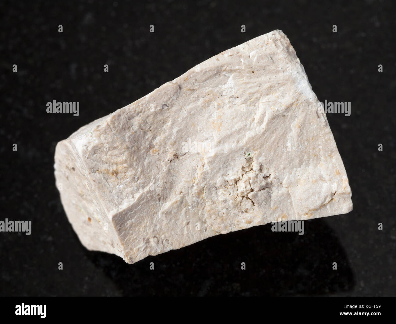 macro shooting of natural mineral rock specimen - raw chemical limestone stone on dark granite background Stock Photo