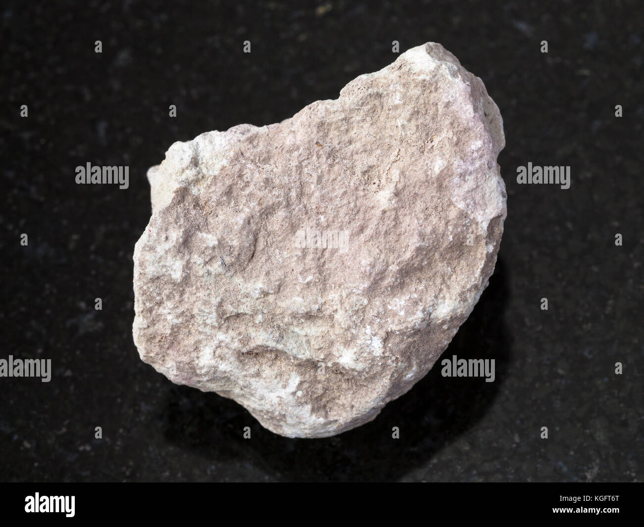 macro shooting of natural mineral rock specimen - rough marl stone on dark granite background Stock Photo