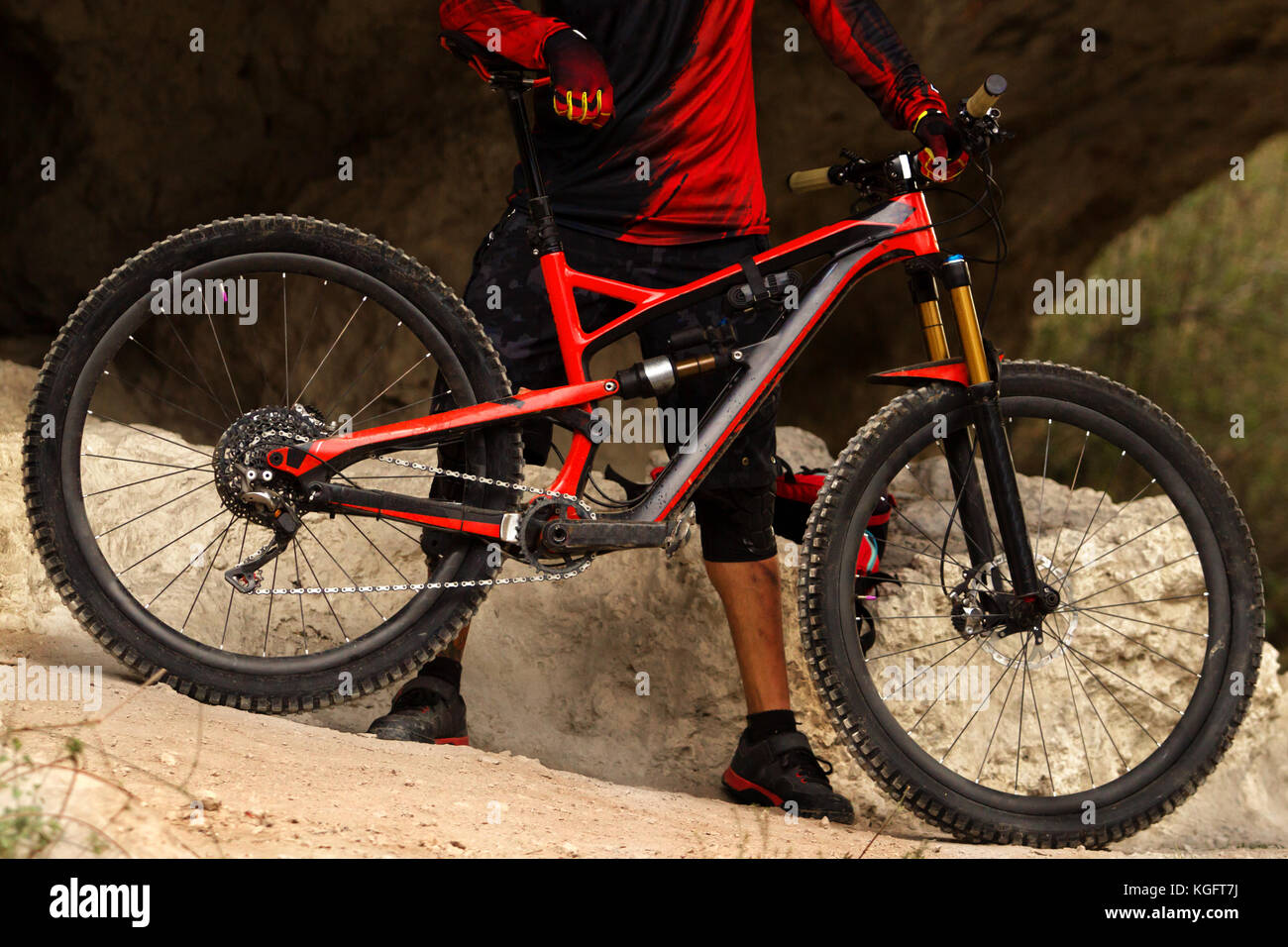 Horizontal photo of a male cyclist holding his enduro full suspension mountain bike in the forest Stock Photo