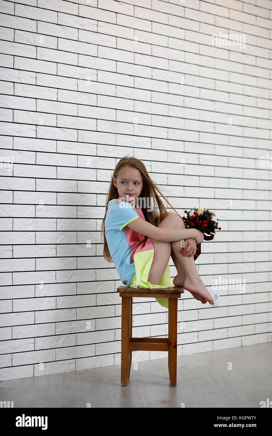 little girl is sitting on a chair Stock Photo - Alamy