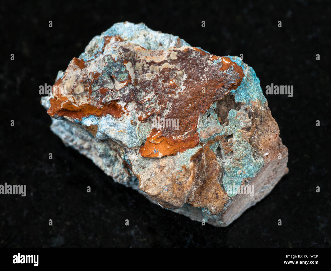 macro shooting of natural mineral rock specimen - raw Scorodite stone on dark granite background from Jezkazgan region, Kazakhstan Stock Photo