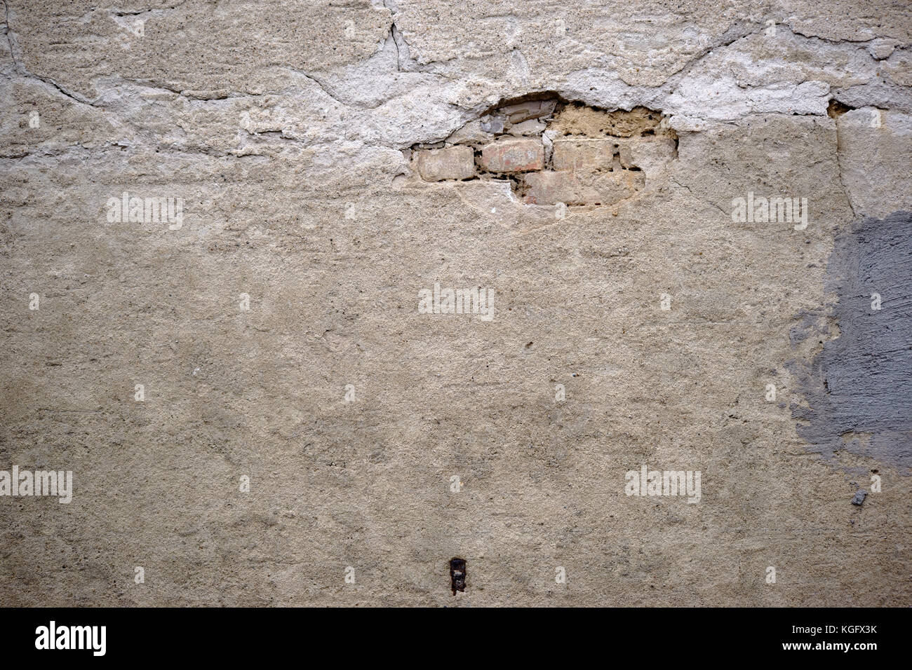 The crumbling plaster layers of an old wall with repair points Stock