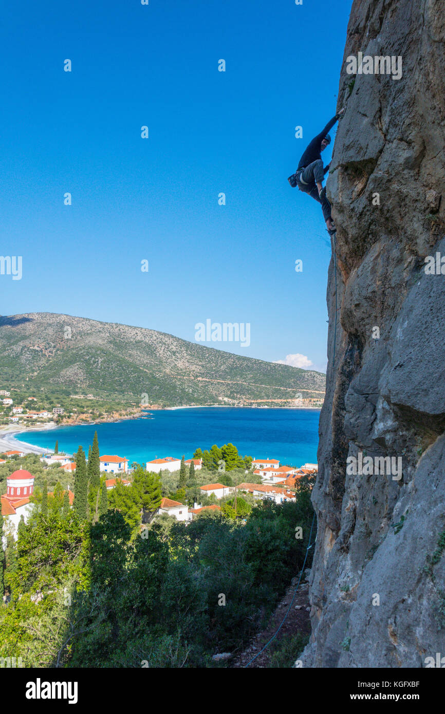 Rock climber silhouetted above Kyparissi, Peloponnes, Greece Stock Photo