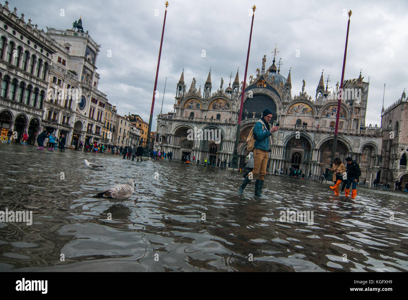 Venice, Italy. 07th November, 2017. Tourists walk in the high water in St Mark square during an high tide on November 7, 2017 in Venice, Italy. Stock Photo