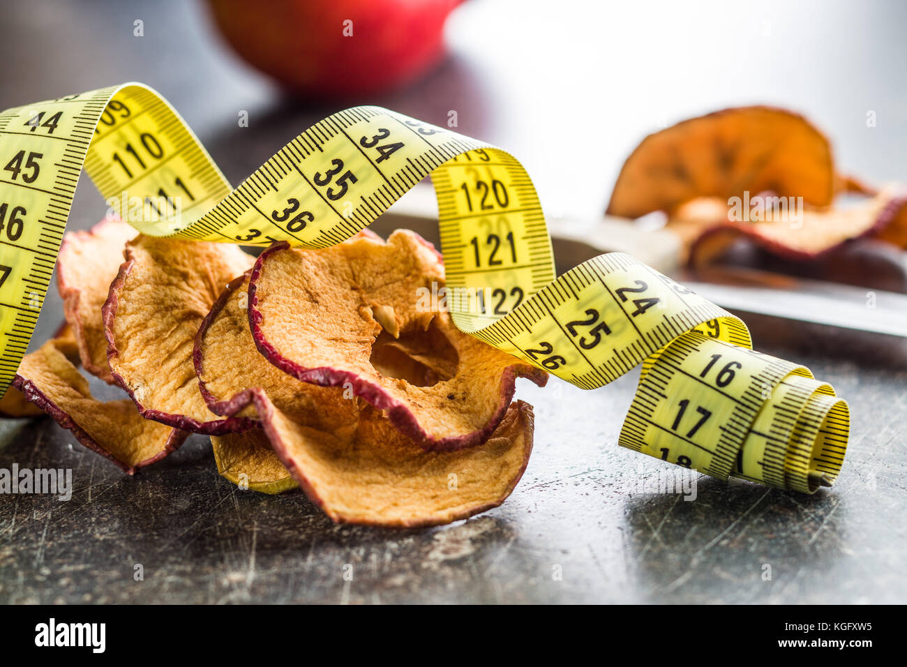 Dried apple slices and measuring tape. Diet concept. Stock Photo
