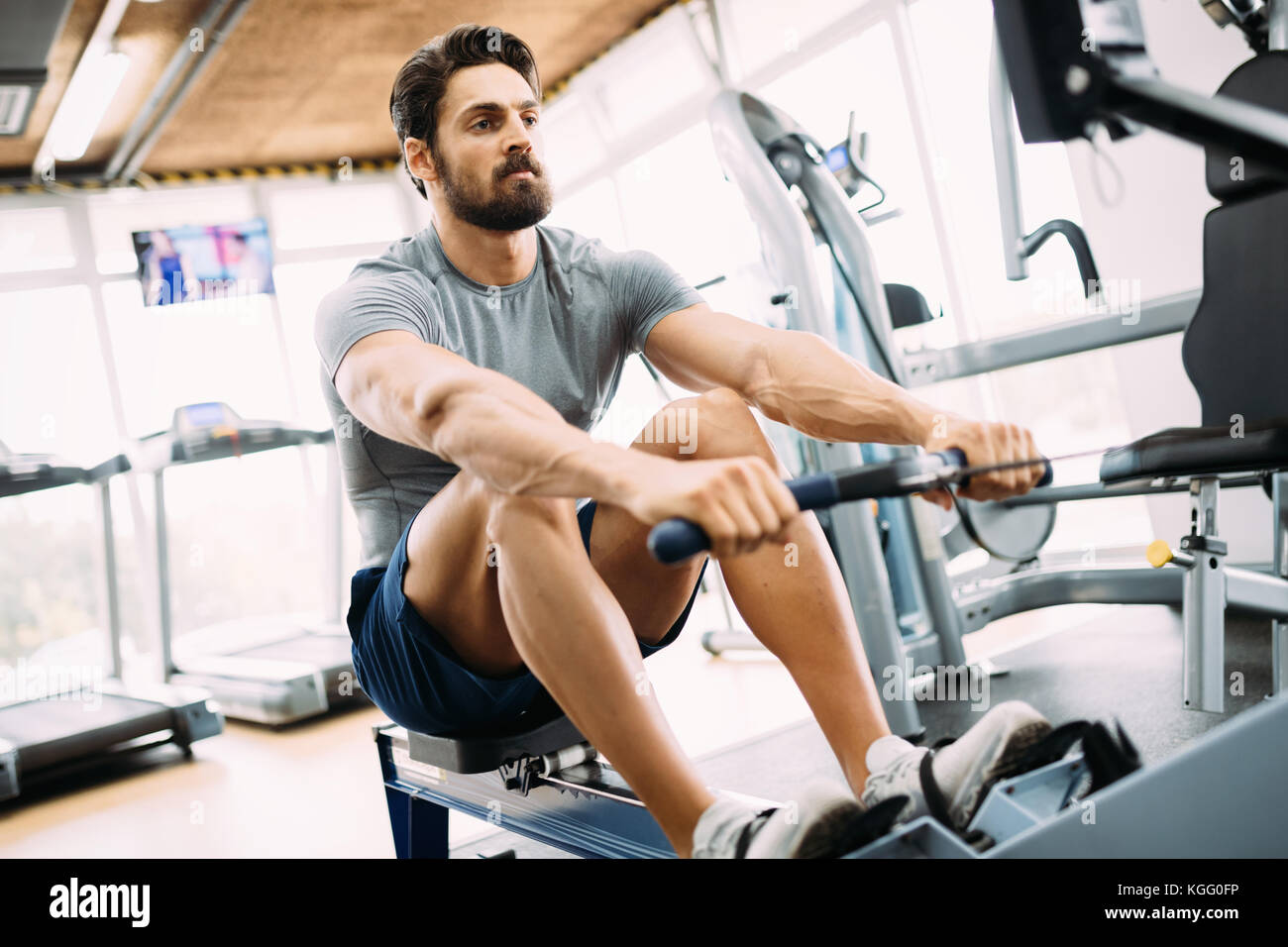 Young handsome man doing exercises in gym Stock Photo