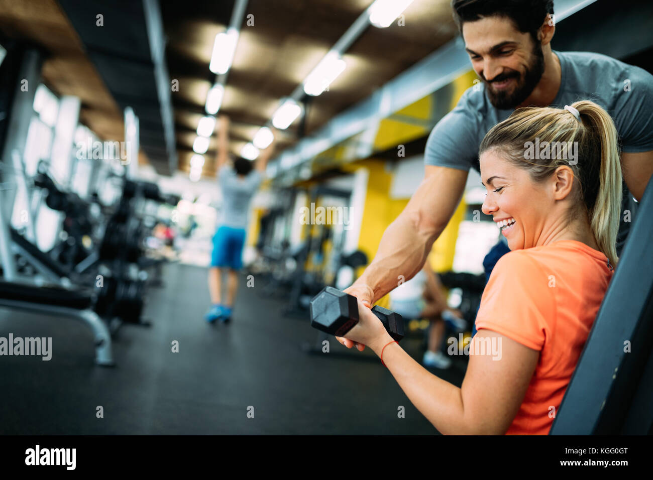 Young beautiful woman doing exercises with personal trainer Stock Photo