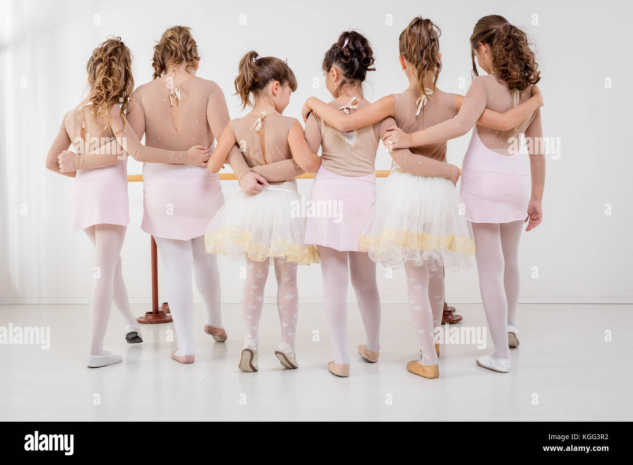 Group of a little girls in dresses during ballet class. Rear view. Stock Photo